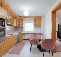 Küche mit Holzdekor und rosa Stühlen in einem Einfamilienhaus.