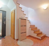Eingangsflur mit Holzdekor, Treppe und Stauraum in einem Einfamilienhaus.