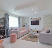 Wohnzimmer in einem Einfamilienhaus mit Kamin, Sofas, Glasvitrine und Sofas.