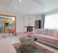 Wohnzimmer mit bequemen Sofas, Kamin und Blick in die Küche in einem Einfamilienhaus.