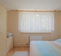 Ein Schlafzimmer mit einem Bett, einem Schrank und einem Holzboden in einem Einfamilienhaus.