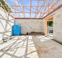 Bau eines Einfamilienhauses in Marcelová mit freiliegendem Holzdachstuhl und unbehandelten Wänden.