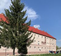Das Gebäude mit roten Dächern und einem Baum davor, in der Železničná-Straße in Šahy.