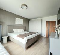 Schlafzimmer in einer 4-Zimmer-Wohnung mit Bett, Schrank und Boden in Holzoptik.