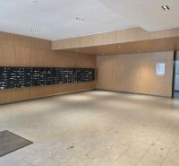 Eingangsbereich mit Briefkästen und Holzverkleidung an den Wänden in einer 4-Zimmer-Wohnung.
