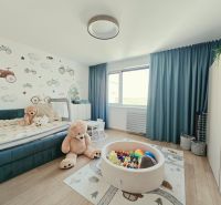 Kinderzimmer in einer 4-Zimmer-Wohnung mit Holzboden, Spielzeug und Wanddekoration.