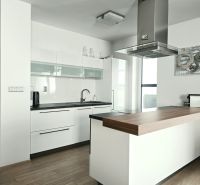 Küche in einer 4-Zimmer-Wohnung mit Küchenzeile und Insel, Boden mit Holzdekor.