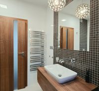 Badezimmer mit hängendem Waschbecken, Holzelementen und Mosaik in einer 4-Zimmer-Wohnung.