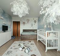 Kinderzimmer in einer 4-Zimmer-Wohnung mit Kinderbett, dekorativem Teppich und Boden mit Holzdekor.