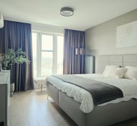 Schlafzimmer in einer 4-Zimmer-Wohnung mit Holzboden und großem Fenster.