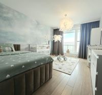 Schlafzimmer in einer 4-Zimmer-Wohnung mit Holzboden, Bett und Kinderbett.
