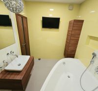 Badezimmer mit hellgelben Wänden, Badewanne, Waschbecken und Spiegel in einer 4-Zimmer-Wohnung.