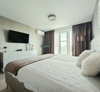 Stilvolles Schlafzimmer in einer 4-Zimmer-Wohnung mit Holzboden und Blick durch ein großes Fenster.
