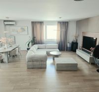 Wohnzimmer mit heller Couchgarnitur, Boden mit Holzdekor, Esstisch, 4-Zimmer-Wohnung.