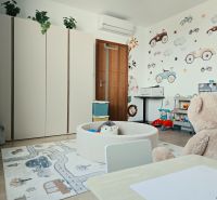 Kinderzimmer in einer 4-Zimmer-Wohnung mit bunten Möbeln, Wanddekorationen und einem Boden in Holzoptik.