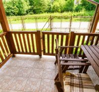 Eine Holzterrasse mit Blick auf den Garten in einem Einfamilienhaus.