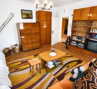 Wohnzimmer in einem Einfamilienhaus mit Teppich, Möbeln, Fernseher und Ofen.