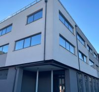 Ein Gebäude mit großen Fenstern in der Komenského 2A 2B in Levice, geeignet für Geschäftsräume.