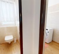 Badezimmer in einer 3-Zimmer-Wohnung mit WC, Waschmaschine und Holzboden.