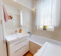 Badezimmer in einer 3-Zimmer-Wohnung mit Badewanne, Waschbecken und Stauraum.