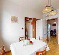 Küche in einer 3-Zimmer-Wohnung mit Holzboden, weißem Tisch und Stühlen.