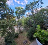 Blick vom Balkon einer 3-Zimmer-Wohnung in der Hospodárska-Straße in Trnava, mit Spielplatz und Bäumen.
