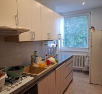 Küche in einer 3-Zimmer-Wohnung mit Holzboden und hellen Schränken.