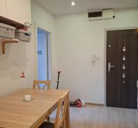 Esszimmer in einer 3-Zimmer-Wohnung mit Holzboden und Holztisch.