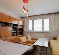 Wohnzimmer in einer 2-Zimmer-Wohnung mit Teppichmustern und gelben Sofas.
