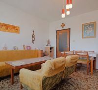 Retro-Wohnzimmer in einer 2-Zimmer-Wohnung mit Teppichboden und Holzdekor.