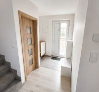 Innenraum eines Einfamilienhauses mit Holzboden, Treppe und Holztüren.
