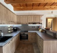 Küche mit Holzschränken und Holzboden in einem Einfamilienhaus.