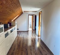 Ein Flur in einem Einfamilienhaus mit einem Boden in Holzoptik und einer Holzdecke.