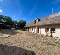 Ein Einfamilienhaus in Hronská Dúbrava mit einem großen Garten und Holzanbauten.