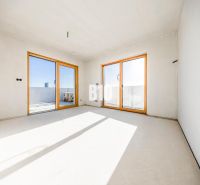 Ein geräumiges Zimmer mit großen Fenstern und Aussicht, helle Wände, 3-Zimmer-Wohnung.