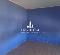 Ein Zimmer in einem Einfamilienhaus mit blauen Wänden und einem Boden in Holzoptik.