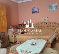 Wohnzimmer mit Kachelofen und Sofa in einem Einfamilienhaus.