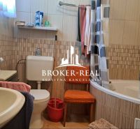 Ein Badezimmer in einem Einfamilienhaus mit einer Badewanne, einem Waschbecken und bunten Handtüchern.
