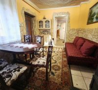 Esszimmer in einem Einfamilienhaus mit einem dekorativen Tisch und einem roten Sofa.