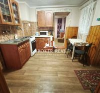 Küche in einem Einfamilienhaus mit Holzdekor, Schränken und Essecke.