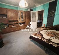 Ein Zimmer in einem Einfamilienhaus mit Holzmöbeln, grünen Wänden und einem bequemen Bett.