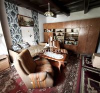 Wohnzimmer in einem Einfamilienhaus mit Teppichen und einer Wohnwand aus Holz.