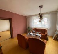 Wohnzimmer eines Einfamilienhauses mit Holzboden und gestreiftem Sofa.