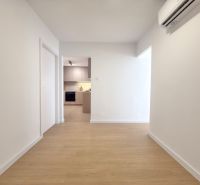 Flur in einer 3-Zimmer-Wohnung mit Holzboden und Klimaanlage.