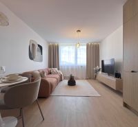 Wohnzimmer in einer 3-Zimmer-Wohnung mit Holzboden, Sofa und Esstisch.