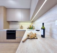 Küche in einer 3-Zimmer-Wohnung mit Wein, Brot und einem Boden in Holzoptik.