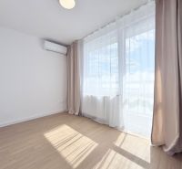 Ein Zimmer mit Holzboden und Klimaanlage in einer 3-Zimmer-Wohnung.