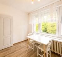 Essbereich mit weißem Tisch und Stühlen, Boden mit Holzdekor, 3-Zimmer-Wohnung.