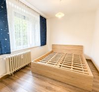 Schlafzimmer mit Holzboden und Bett in einer 3-Zimmer-Wohnung.