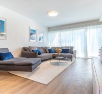 Wohnzimmer in einem Einfamilienhaus mit Sofa, Bildern und Boden mit Holzdekor.